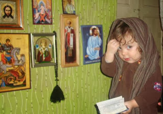 A child venerating icons. Soruce